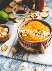 Pumpkin soup with carrots and homemade croutons in clay pots, ru