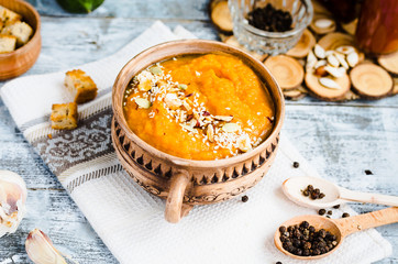 Pumpkin soup with carrots and homemade croutons in clay pots, ru