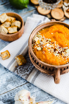 Pumpkin soup with carrots and homemade croutons in clay pots, ru