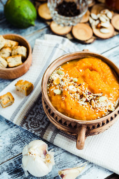 Pumpkin soup with carrots and homemade croutons in clay pots, ru
