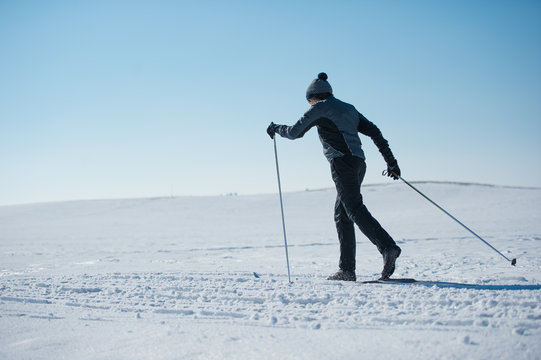 Junger sportlicher Mann beim Langlaufen im Winter