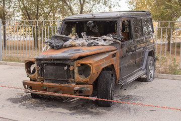 Obraz na płótnie Canvas Front view of the burned large SUV