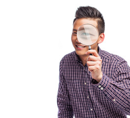 Fototapeta na wymiar portrait of a young asian man looking through a magnifying glass