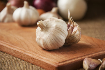 Garlic on cutting board , close-up on sacking. burlap background