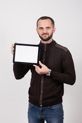 a man on a white background in a brown jacket and blue jeans hol