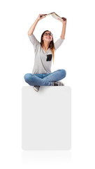 young woman reading a book sitting on a white placard