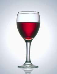 a glass of red wine on a gray background