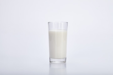 Glass cup with milk on a white background.