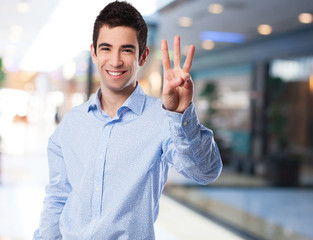 cool young man  doing number three sign