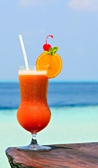 Glass of drink is on a beach table