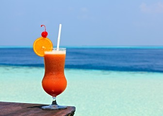 Glass of drink is on a beach table