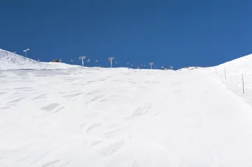 Afwasbaar fotobehang Snowy ski piste on a mountain © Paul Vinten