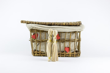Two straw dolls in front of an old casket