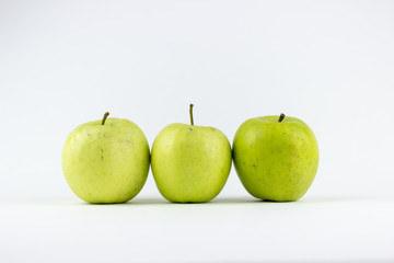 Three green apples on a white background