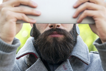 young hipster businessman holding the laptop in front of face