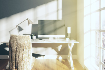 Modern sunny room with computer on the table and wooden floor