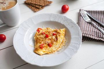 omelette with tomato and cheese on the table with coffee