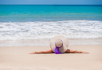 Fototapeta na wymiar woman with straw hat on the beach