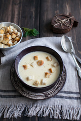 cheese soup with crackers on a plate on a napkin with appliances