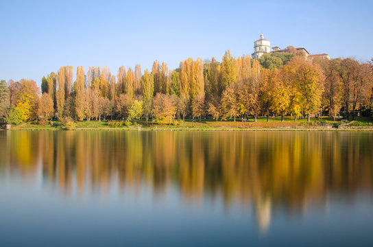 Alberi in autunno con riflesso sul fiume