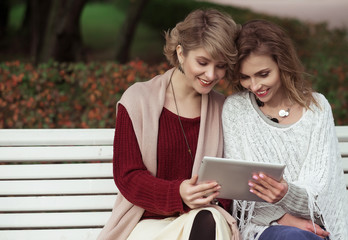 beautiful women girls autumn using tablet outdoor