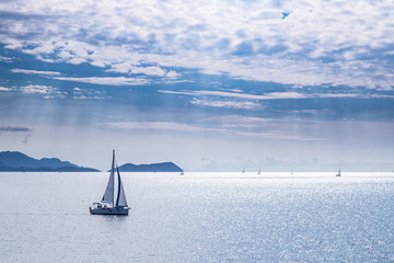Sailing boat on blue sea waters with clear blue sky