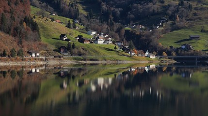 Fototapeta na wymiar Innerthal, little village in Schwyz Canton mirroring in lake Wagital