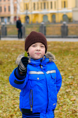 Boy in a blue jacket holding a green leaf