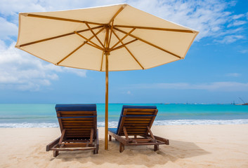 Beach chairs with umbrella and beach on a sunny day