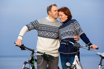 Obraz premium Cheerful couple biking on a sand beach
