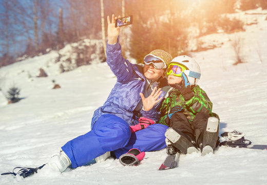 Mother with son make a selfy on the snow mountain hill
