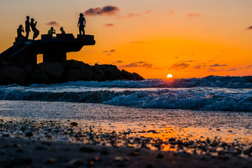 Sillhouette of people in the beach during sunset