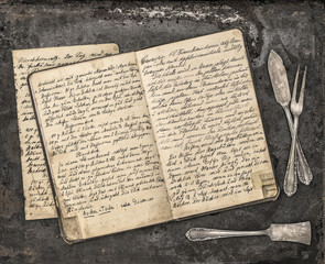 Obraz premium Vintage handwritten recipe book and antique silverware