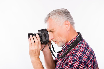 Side view of an aged photographer taking a photo