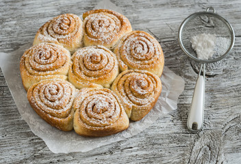 cinnamon rolls on bright wooden surface