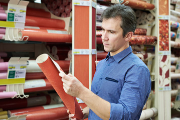 Man shopping red wallpapers in DIY shop