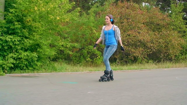 Teenage girl with headphones roller skating in park 