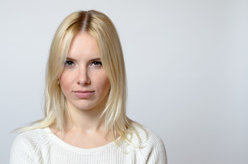 Naklejka premium Blond Woman Staring at the Camera Against Gray