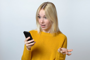 Fototapeta premium Surprised Young Woman Looking at her Mobile Phone
