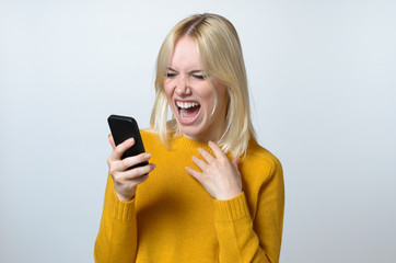 shocked Young Woman Looking at her Mobile Phone