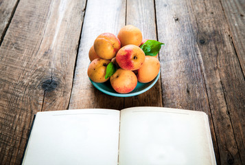 delicious fruit. apricots with a book on a wooden background