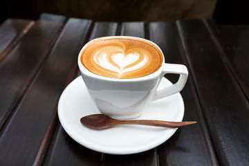 Cup of latte coffee on wood background