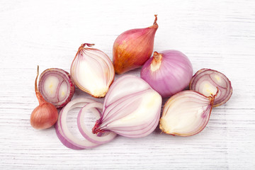red onion bulb on white wood table