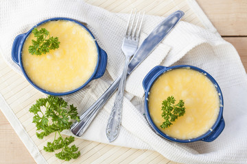 Julienne with mushrooms and cream. Mushroom and cheese gratin in ceramic bowls, on wooden background