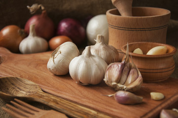 Garlic on cutting board , close-up on sacking. burlap background