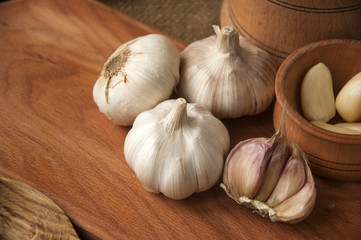 Garlic on cutting board , close-up on sacking. burlap background