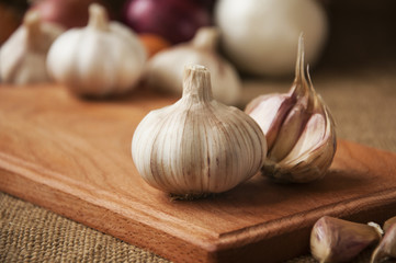 Garlic on cutting board , close-up on sacking. burlap background