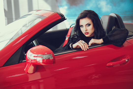 close up portrait of Young pretty brunette lady with a modern luxury car