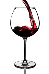 Red wine pouring into glass on white background