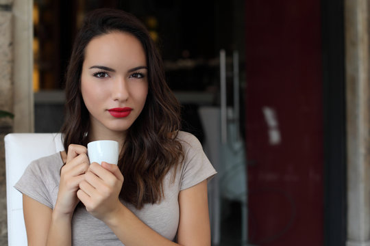 Girl sitting in cafe drinking coffee